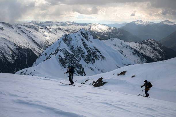istock Backcountry skiers climb mountain 2150645378