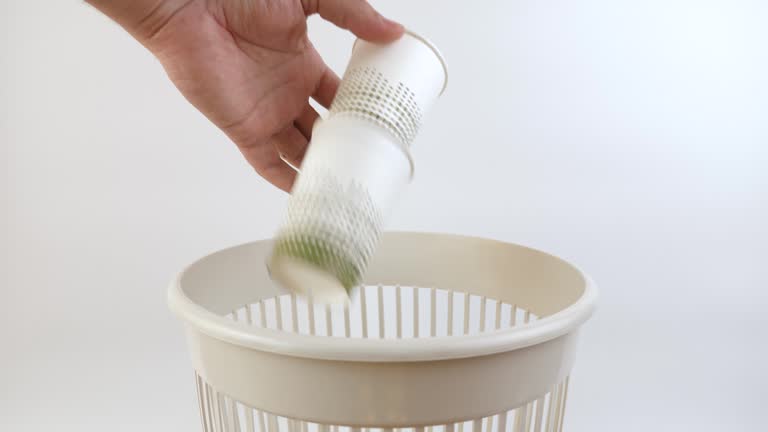 Disposable paper cups are thrown into the trash. Disposal of household waste. Slow motion