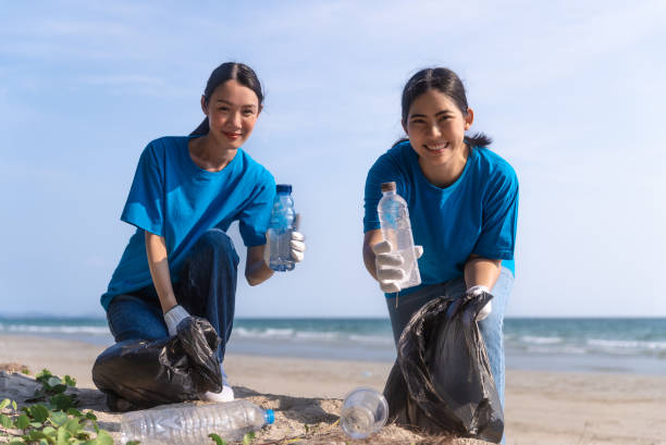 istock Plastic pollution and environmental problem concept. Happy asian diverse group of volunteers with garbage bags wearing blue t-shirt and cleaning plastic on the beach. Volunteers collecting trash. 2150649300