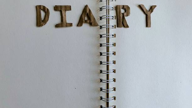 istock Notebook, diary, paper, pencil, brown, black and white on the table. 2150649345