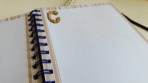 istock Notebook, diary, paper, pencil, brown, black and white on the table. 2150649384