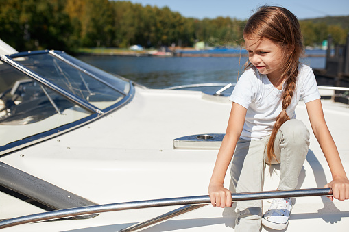little girl on boat deck sails on summer day