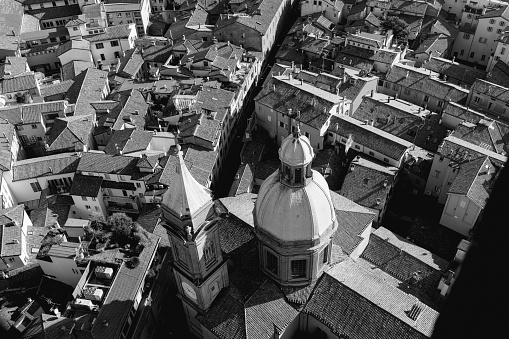 A black and white aerial view of Bologna city center, focusing on the Church of Saints Bartholomew and Cajetan. The image captures the dense rooftops, narrow streets, and historic buildings surrounding the church