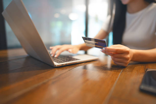 istock Woman hand consumer using creadit card and laptop on wooden table 2150652793