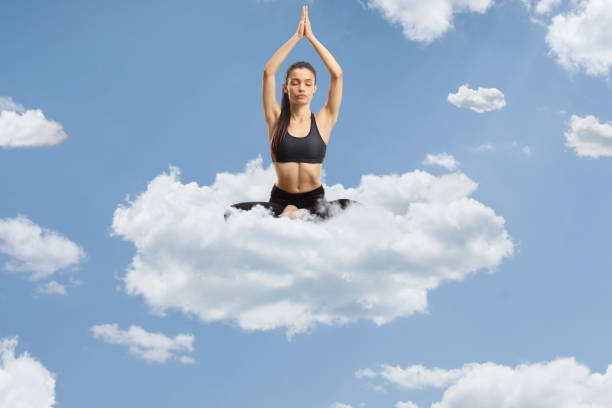 istock Young woman exercising yoga on a cloud 2150657214
