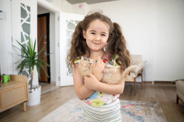 istock Adorable girl playing with her cat at home. 2150657437