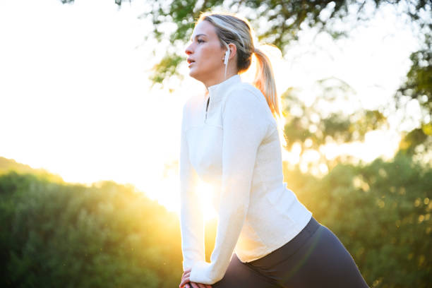 istock Young woman breathing deep stretching doing lunges in the park 2150659857