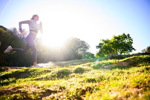 istock Low angle view young woman runner in park at sunrise 2150660328