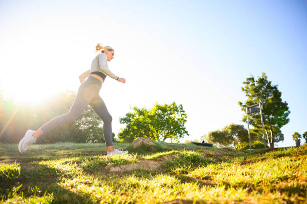istock Low angle view young woman runner in park at sunrise 2150660329