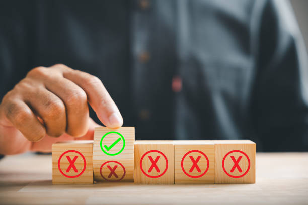 istock Flipping wooden cube from red cross to correct tick by hand symbolizing project approval concept. Close-up choice change. Think With Yes Or No Choice. 2150661065