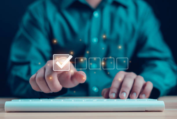istock Hands check the checklist manually and fill out the online survey form. Document management system, assessment forms, questionnaires, checklists 2150661452