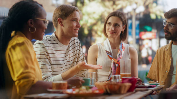 istock Two Diverse Couples Spending Time Together on a Double Date, Enjoying Delicious Food at an Outdoors Pizzeria. Multiethnic Young Men and Women Having Joyful Conversations, Smile and Laugh at Jokes 2150663536