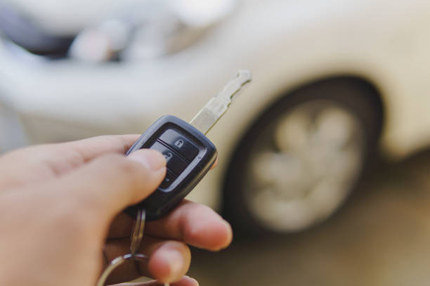 istock Hand holding key and pressing unlock button to open car doors 2150663981