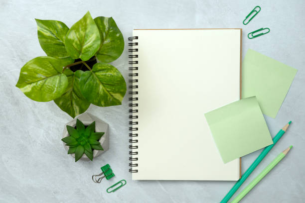 istock Notebook and green sticky note and stationery on stone texture background. Work desk space 2150669043