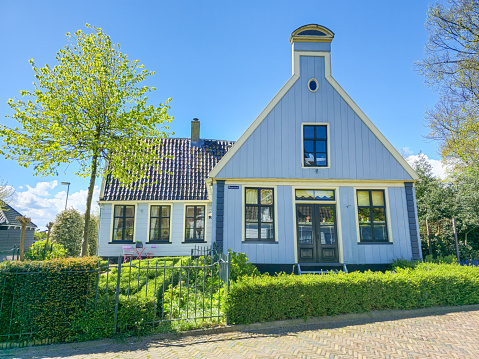 Broek in Waterlands Netherlands 21 April 2024, A stunning white house with a vibrant blue roof and windows stands out against the clear sky, exuding charm and elegance.