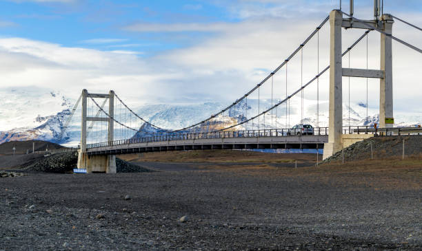 istock A bridge over a snowy mountain with a car driving across it 2150670221