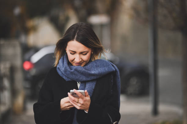 istock Woman using mobile phone outdoors. 2150670468