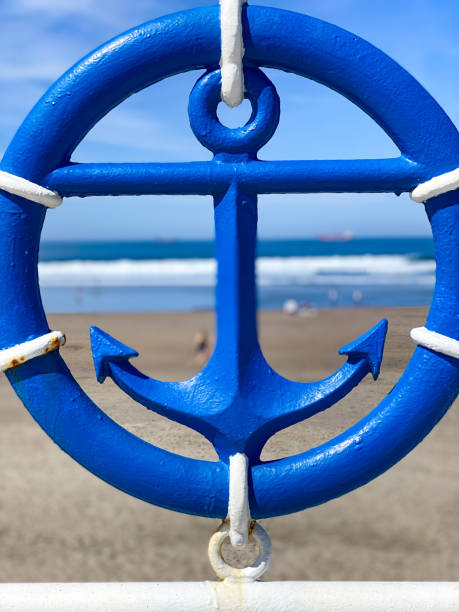 Blue anchor on sea and sandy beach background, summer vacation travel background