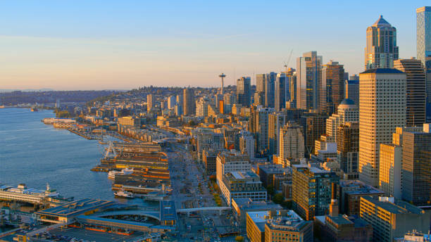 Aerial view of Seattle cityscape with waterfront in golden light of setting sun, Seattle, Washington State, USA.