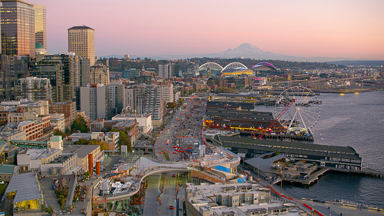 Aerial view of cityscape with Seattle Waterfront and The Seattle Great Wheel against Mount Rainier at sunset, Seattle, Washington State, USA.