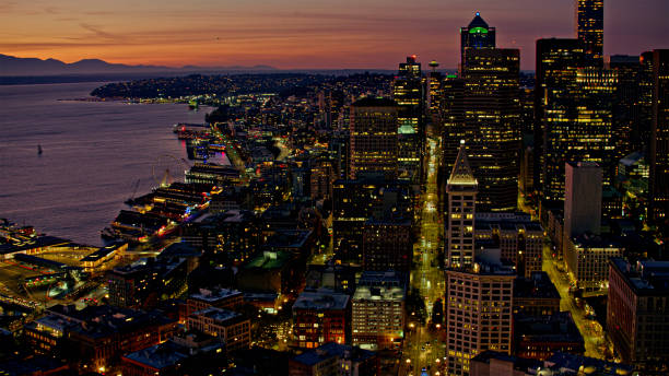 Aerial view of illuminated city with Central Business District along Elliott Bay at night, Seattle, Washington State, USA..