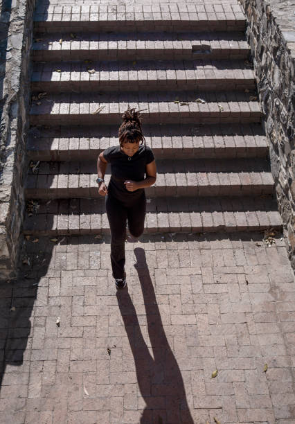 istock Fit young woman sprinting down city steps during a run 2150672499