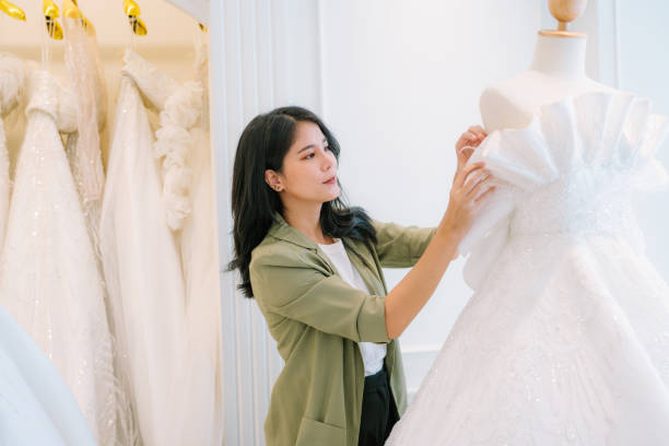 istock Attractive young bride is smiling while choosing wedding dress. 2150673776