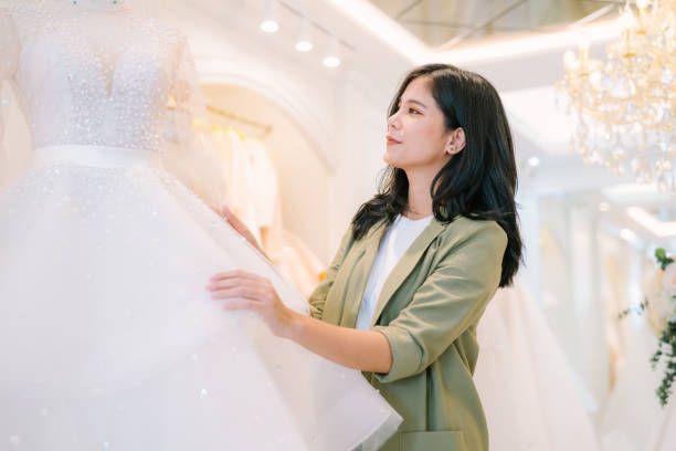 istock Attractive young bride is smiling while choosing wedding dress. 2150674614