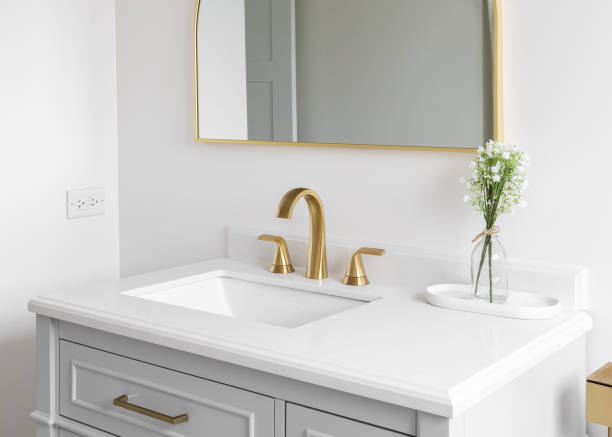 istock A golden faucet on a white marble countertop. 2150674763