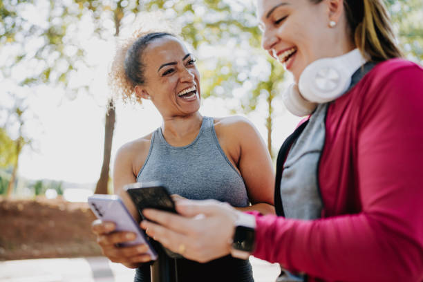 istock Two fitness friends smiling using smartphone 2150678987