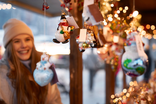 Caucasian young woman watching Christmas decorations on Christmas market
