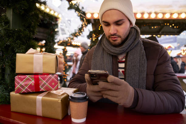 istock Man browsing phone on Christmas Market 2150680427