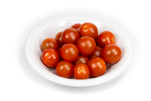 Closeup of a plate full of cherry tomatoes on white background