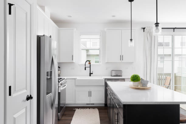 istock A white farmhouse kitchen with a black island. 2150681160