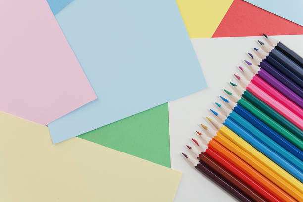 istock Colorful pencils lying on colorful cardboard sheets 2150681756