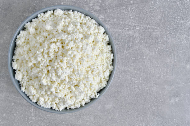 istock Cottage cheese in plate gray concrete background, top view. 2150683662
