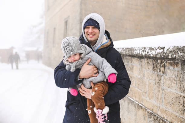Father with daughter in winter street.