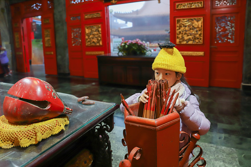 An Asian girl goes to the temple to pray before the Lunar New Year. She is praying for her grades to improve and her family to be safe and healthy. Going to temples to worship is a lifestyle habit of most Chinese people, most of whom believe in Taoism.