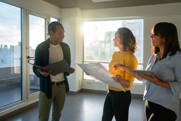 istock Diverse couple chatting with female architect while planning apartment renovations 2150687020