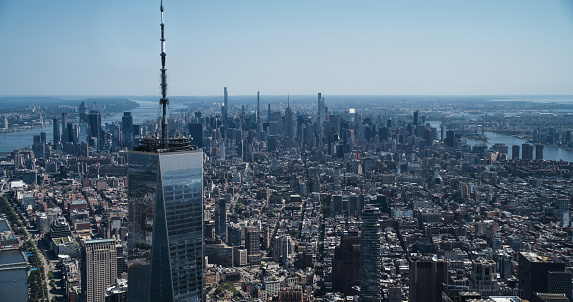 Aerial Photo with Top of the One World Trade Center Skyscraper with Antenna. Helicopter Flying Around the Glass Building with a View on Greater New York City Boroughs