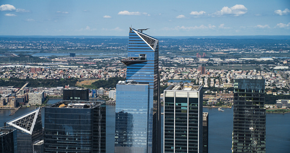 Fly-By Panorama Around the 30 Hudson Yards Skyscraper in New York City, USA. Aerial Footage with a Modern Skyscraper with Crowded Observation Balcony. Travelers Relishing the Panoramic Summer View