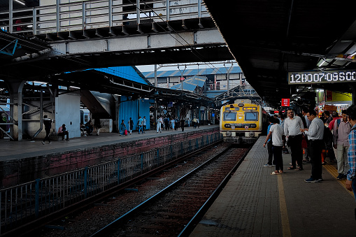 MUMBAI, INDIA - MARCH 02, 2024: Local train coming on the platform at the Mumbai suburban railway station.