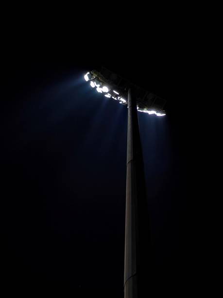 istock A single pole of lights cast blue beams at dark night 2150690740
