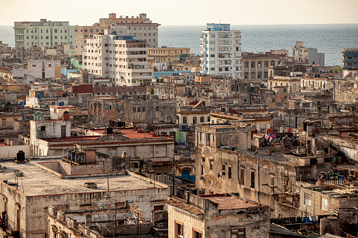 Looking down on the faded and distressed buildings of old Havana, with the ocean in the distance