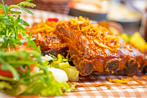 pork thighs in sauce with salad, arugula and pickles. National cuisine of Ukraine.