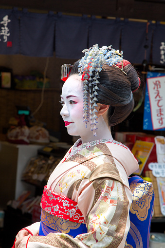 Kyoto, Japan - 15 June 2016: Woman in Geisha costume and makeup on the ancient streets of Kyoto. Famous as an area for Geishas.