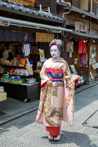 Kyoto, Japan - 15 June 2016: Woman in Geisha costume and makeup on the ancient streets of Kyoto. Famous as an area for Geishas.