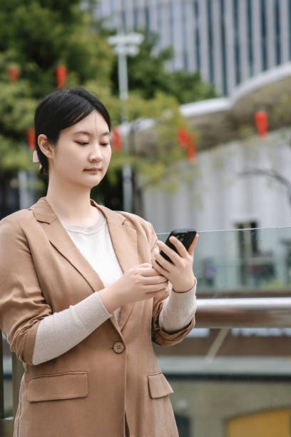 istock Professional Woman Checking Email on Smartphone in City 2150696129