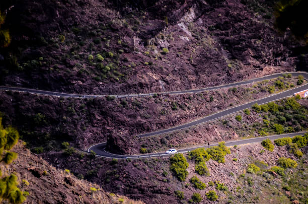 istock A winding road with a white car driving down it 2150697295
