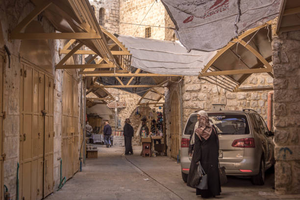 The people on the streets of Hebron with the closed shops of the old city bazaar, in West Bank, Palestine.